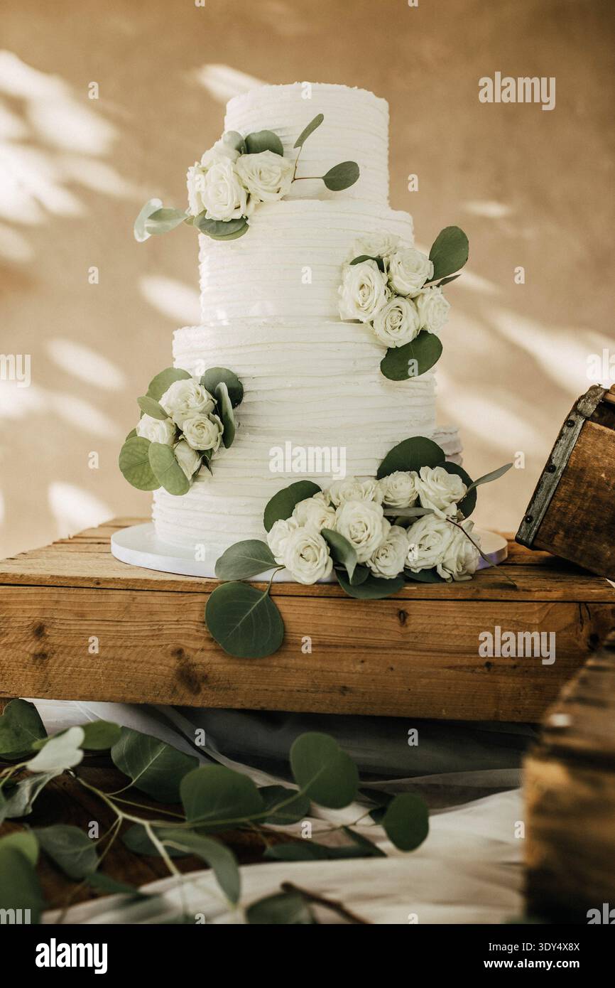 White wedding cake decorated with eucalyptus and roses Stock Photo