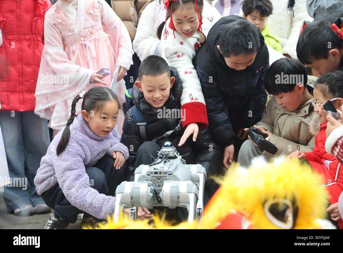 Students interact with humanoid robots and robotic dogs during a ...