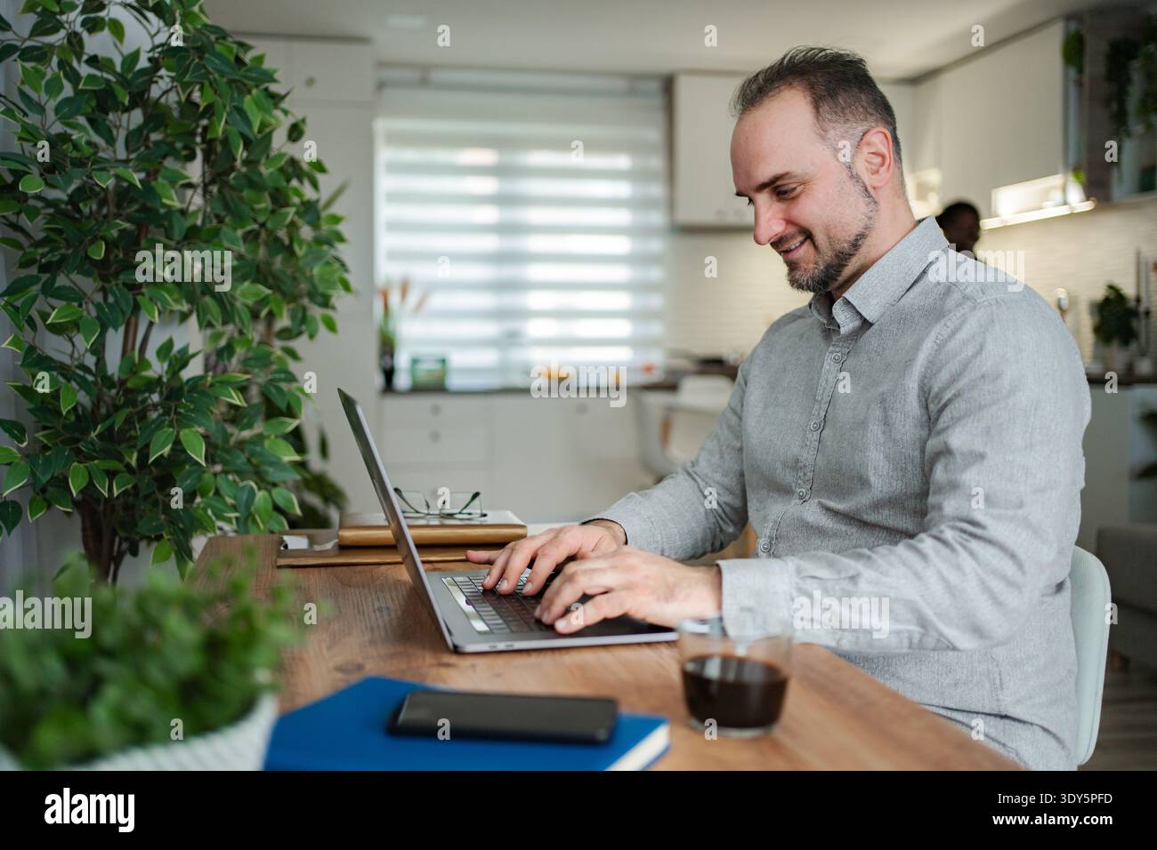 Man working from home typing on laptop Stock Photo