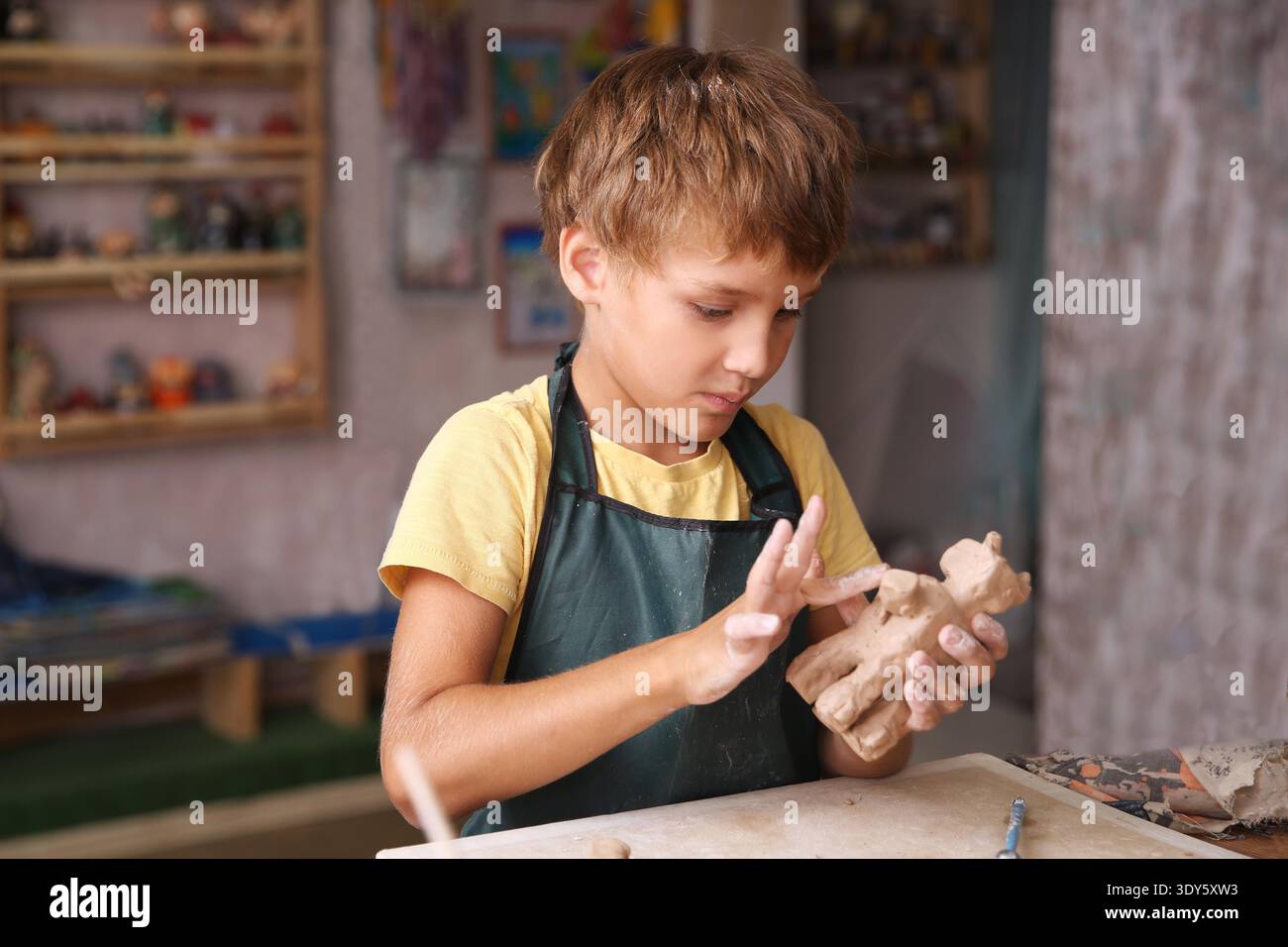 Kids molded from clay at pottery class. || Model released Stock Photo