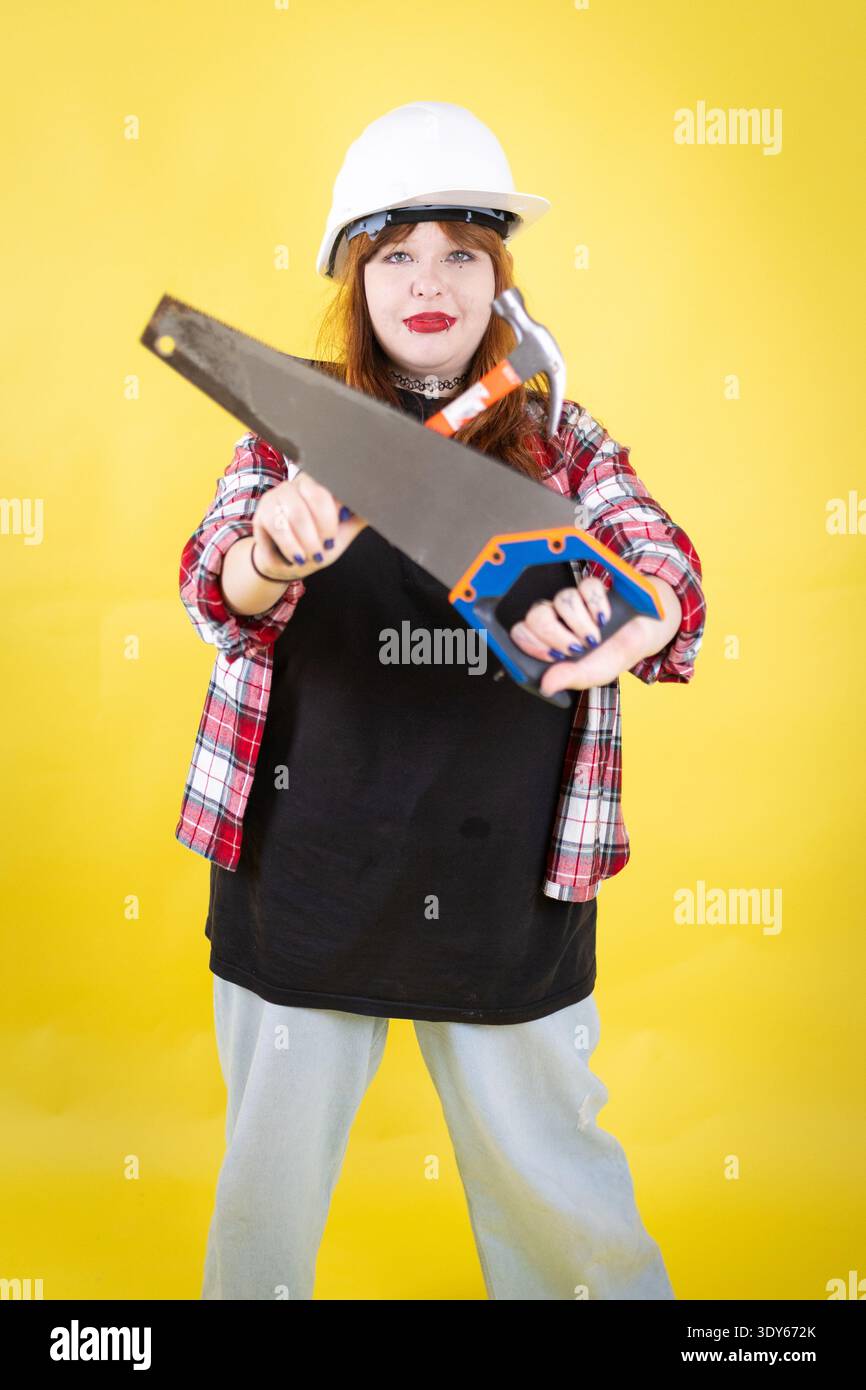 Young woman holding construction tools ready for work Stock Photo