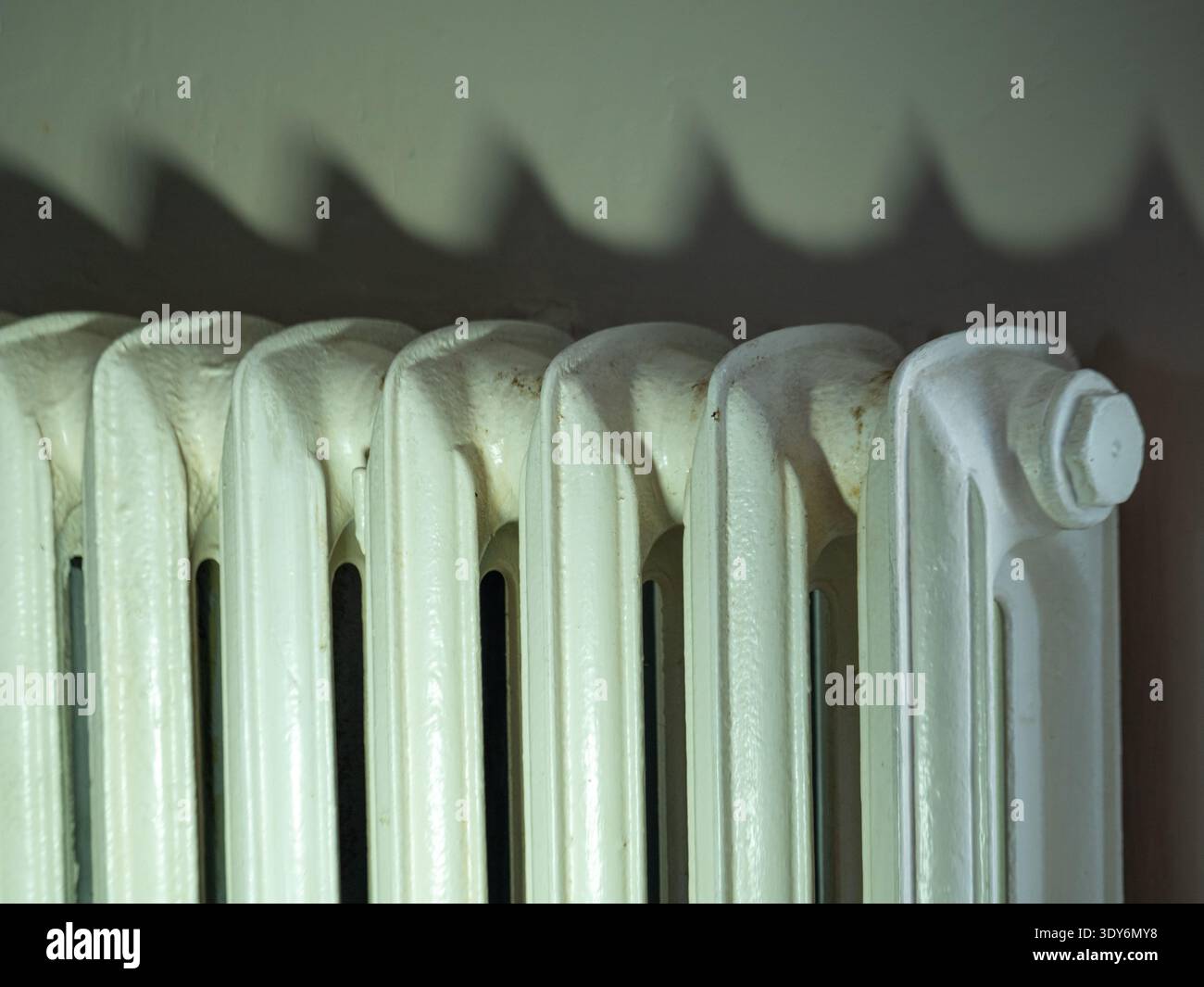 Close-up of a vintage cast iron radiator showing painted metal texture ...