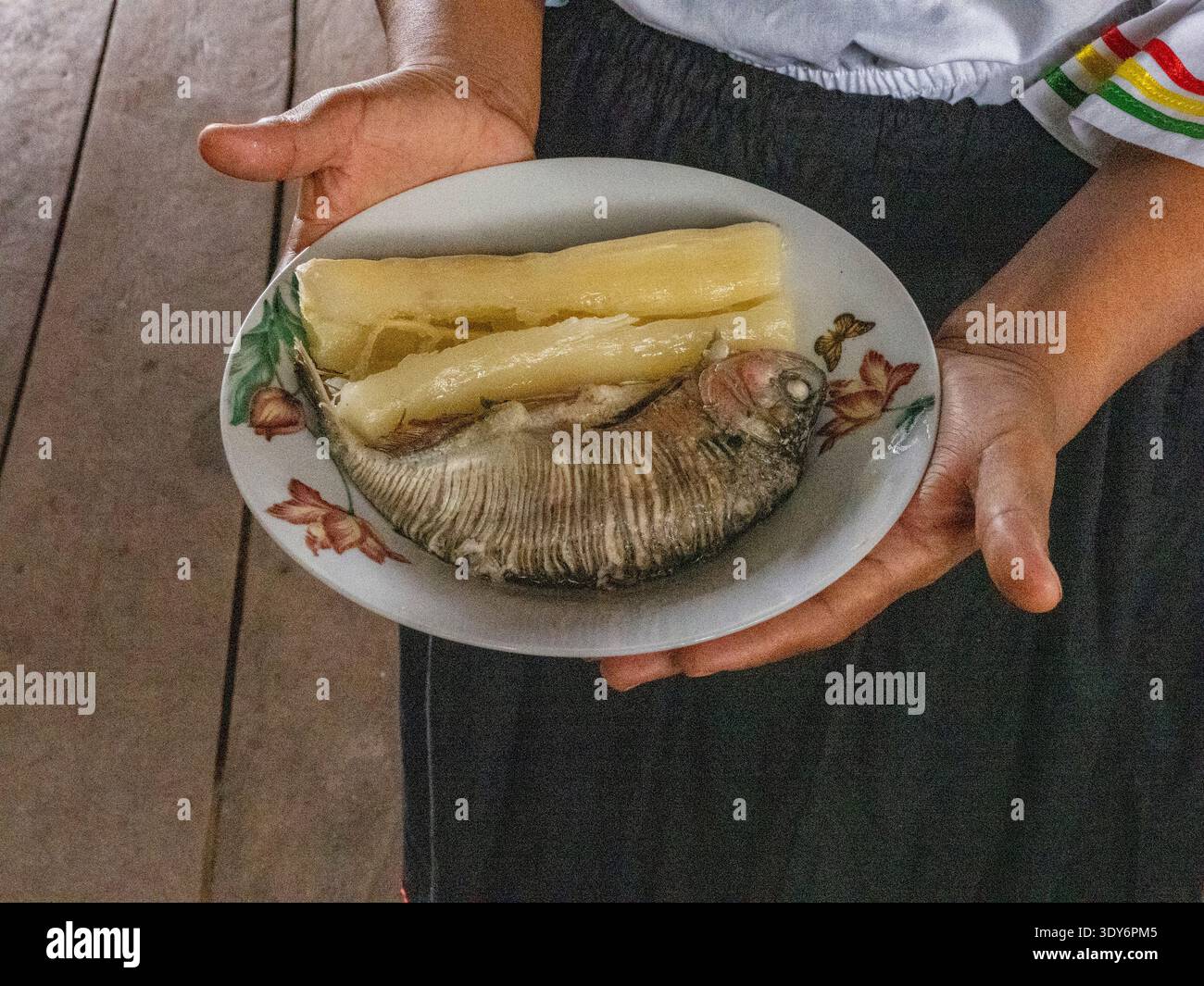 Women from Minga Peru prepare local fish served with cassava in Amazonas on the Maraon River in Loreto, Peru Stock Photo