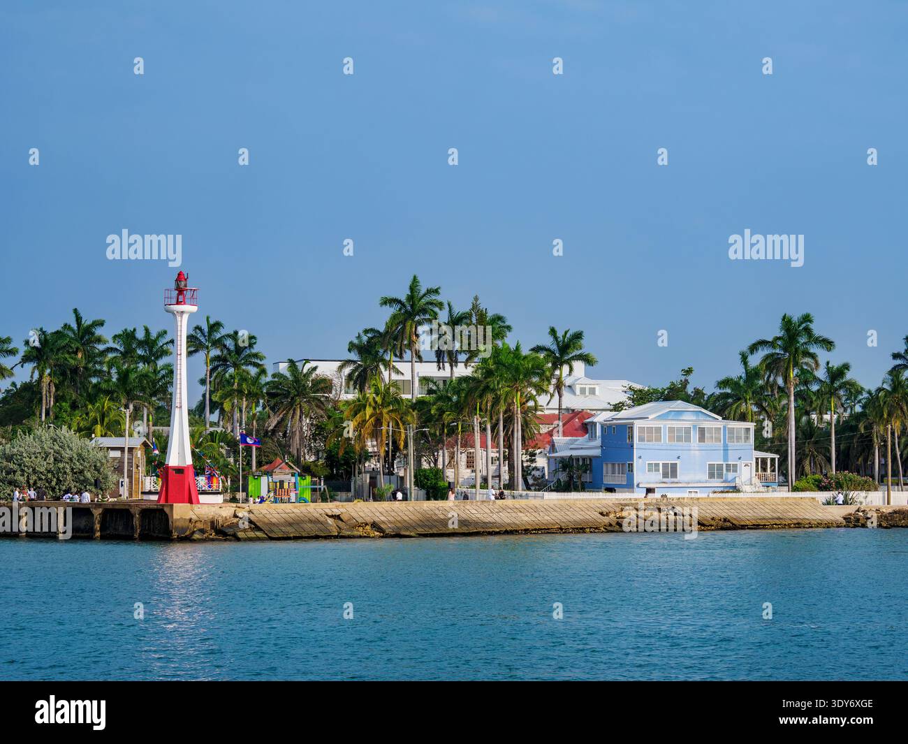 Baron Bliss Lighthouse stands next to waterfront and palm trees in Belize City, Belize during bright daylight hours Stock Photo