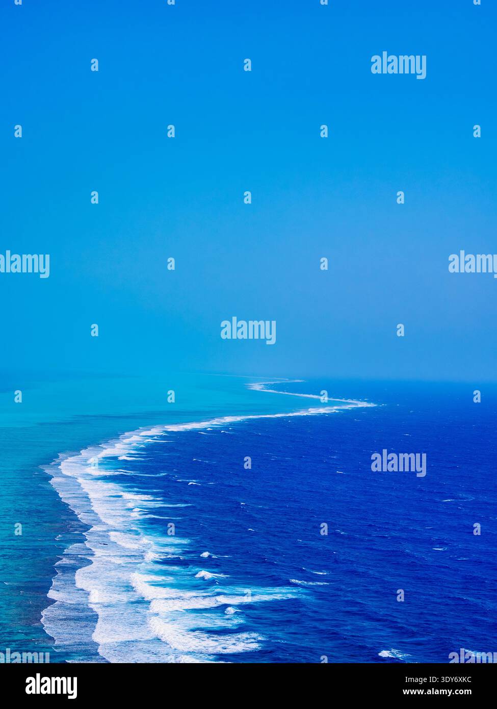 Bright blue waters and white waves stretch across the horizon at Lighthouse Reef in Belize District Stock Photo