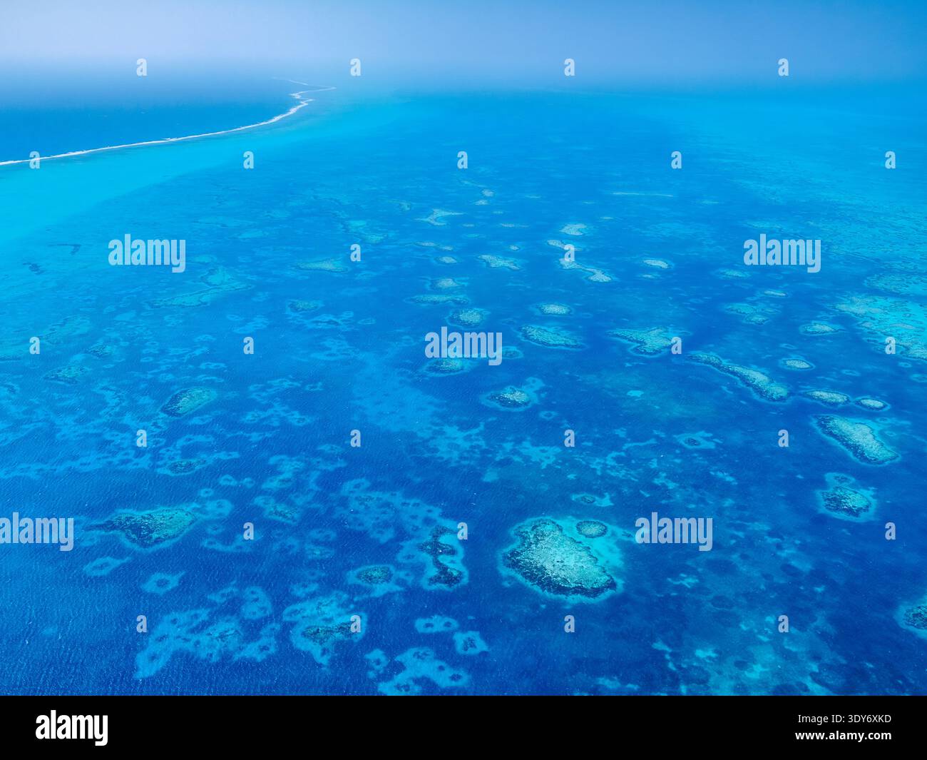 Aerial view of the clear blue water and coral formations at Lighthouse Reef in Belize District Stock Photo