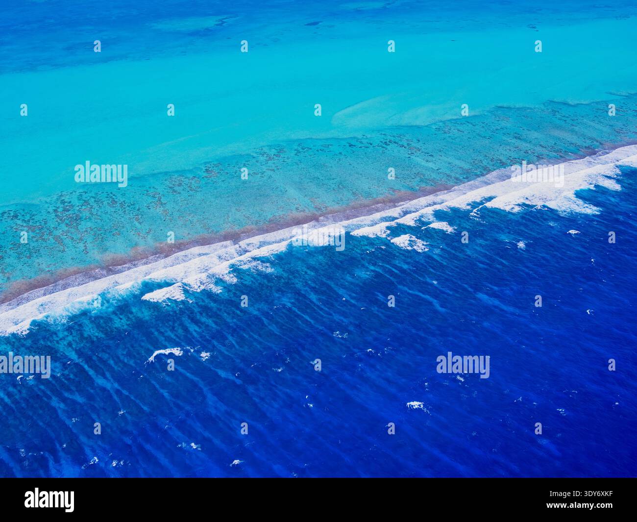 Lighthouse Reef shows clear blue waters and coral atolls in Belize's coastline from above Stock Photo