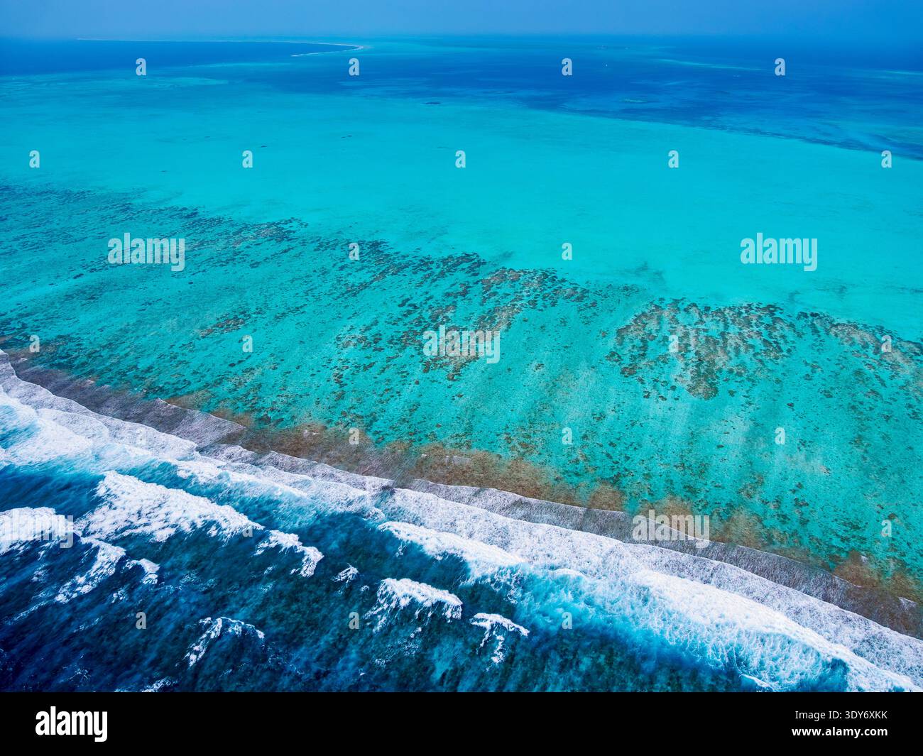 Lighthouse Reef shows a clear view of coral formations and blue waters in Belize District during a bright day Stock Photo