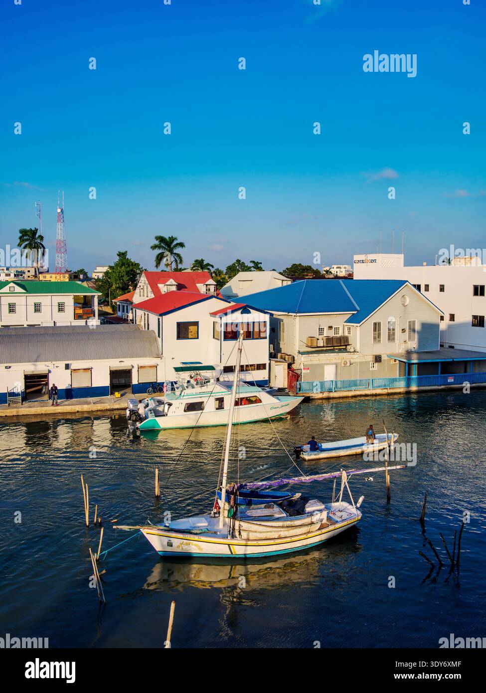 Sunset view of Collet Canal with boats and buildings in Belize City, Belize District, Belize Stock Photo