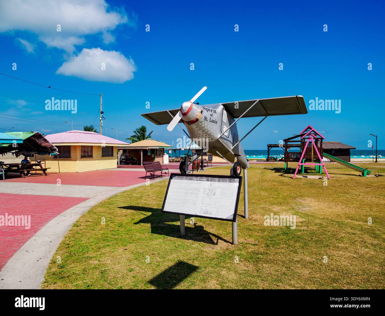 Digi Park features a plane model and playground structure in Belize City with ocean view and bright blue sky Stock Photo