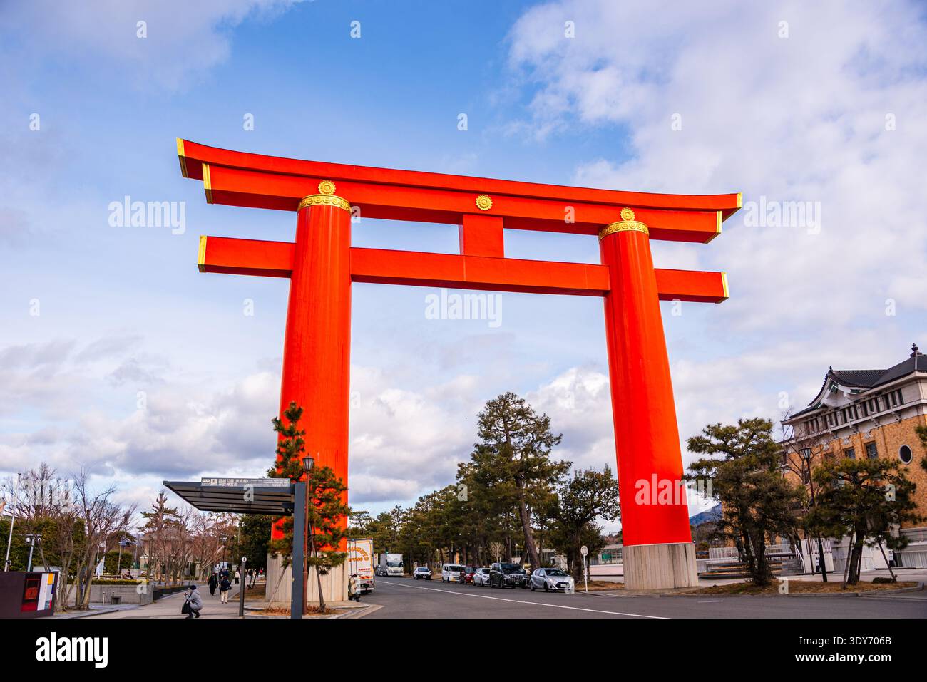 Urban street scene in Kyoto with a bright red torii gate spanning the ...