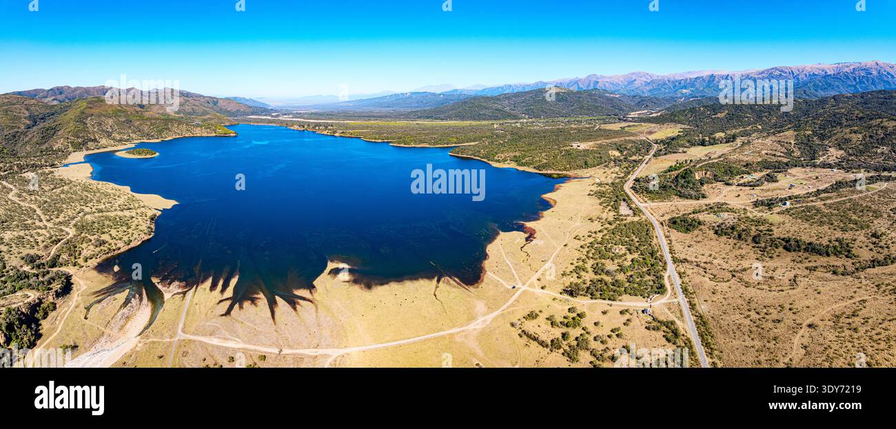Explore the blue waters of Embalse Campo Alegre in Salta, Argentina, under a clear sky and mountain backdrop Stock Photo