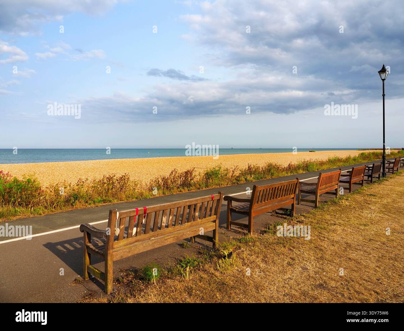 Benches along the beach path in Deal with a view of the sea and the sky in Kent, United Kingdom Stock Photo