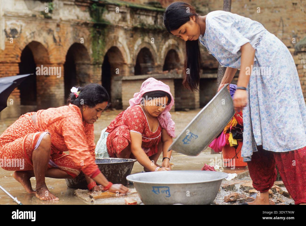 Women wash clothes at a water fountain in Bungamati village near ...