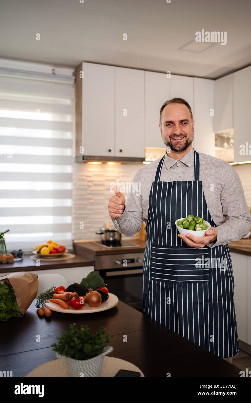Man chef showing organic Brussels sprouts giving thumbs up Stock Photo