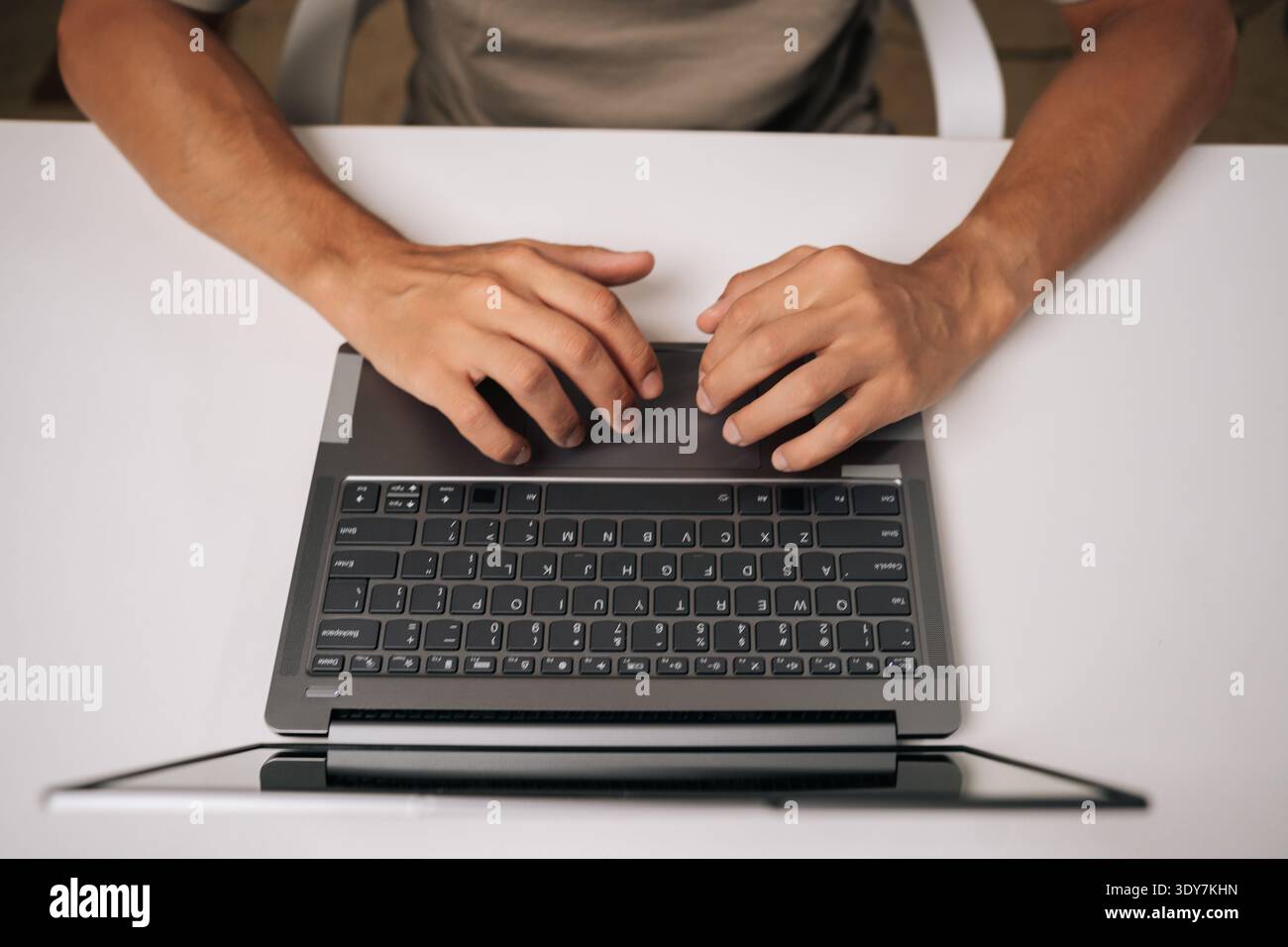 Top view of programmer hands typing complex code on laptop keyboard, revealing intense concentration during software engineering workflow. Stock Photo
