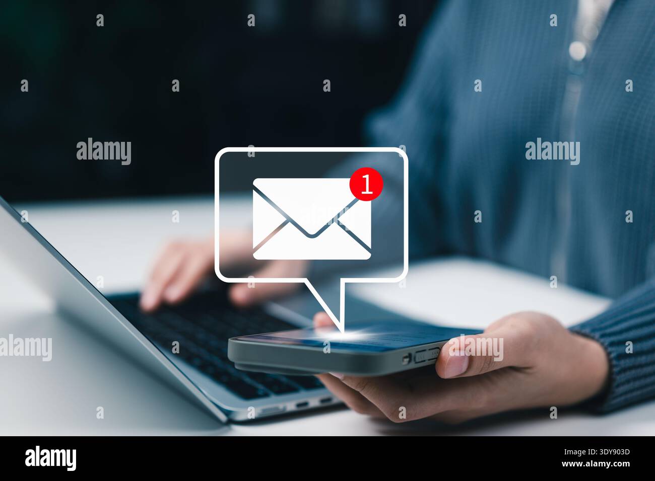 Email notification and online communication concept. User using smartphone receiving new message alert with envelope notification icon while working Stock Photo