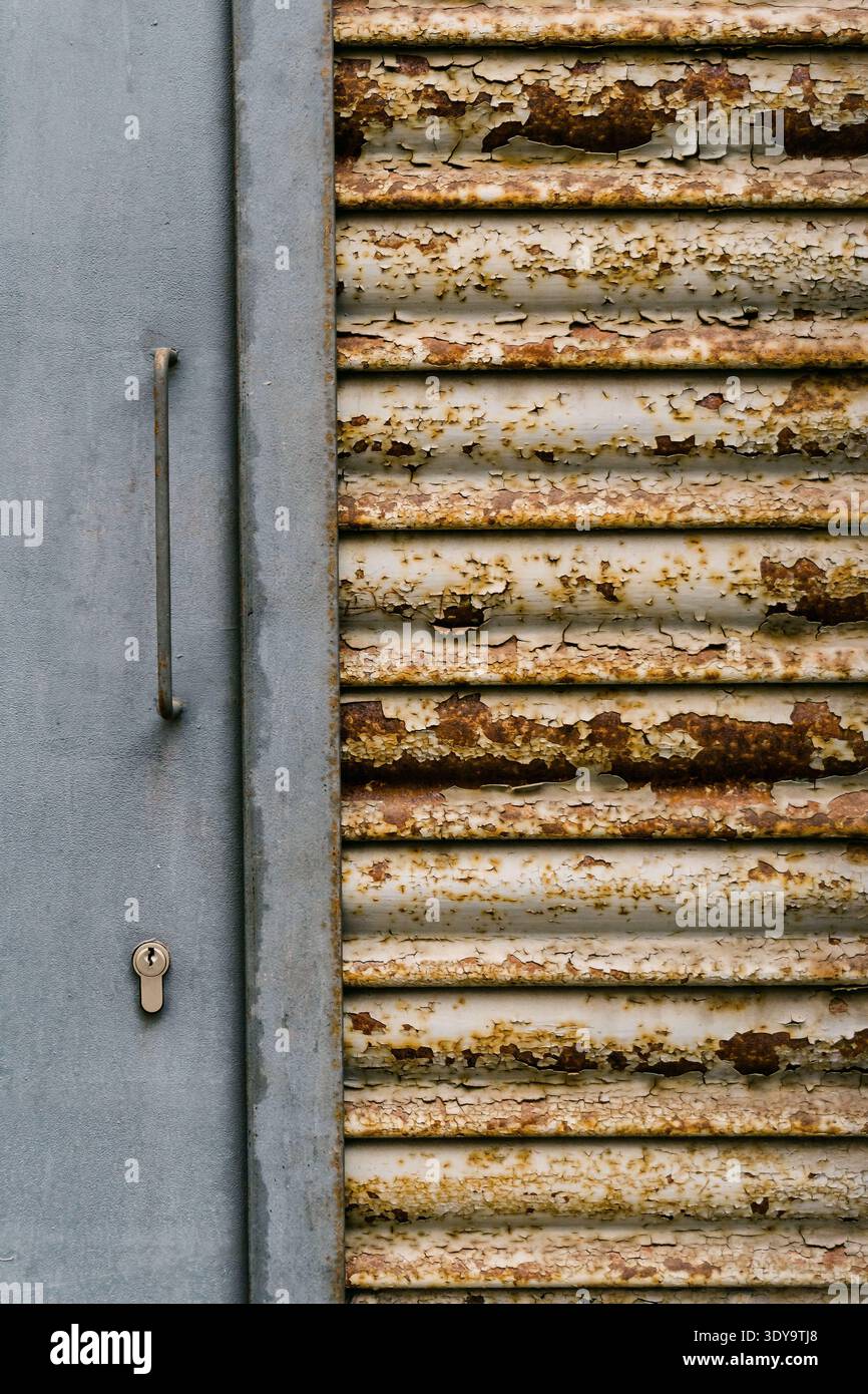 Rusty old shutter and gray door with lock Stock Photo