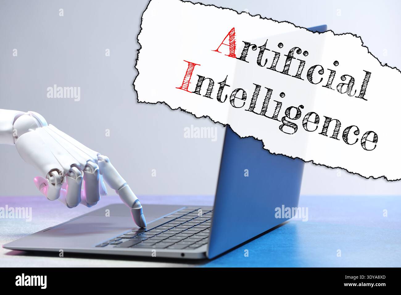 Robot using laptop. Text Artificial Intelligence on torn paper Stock Photo