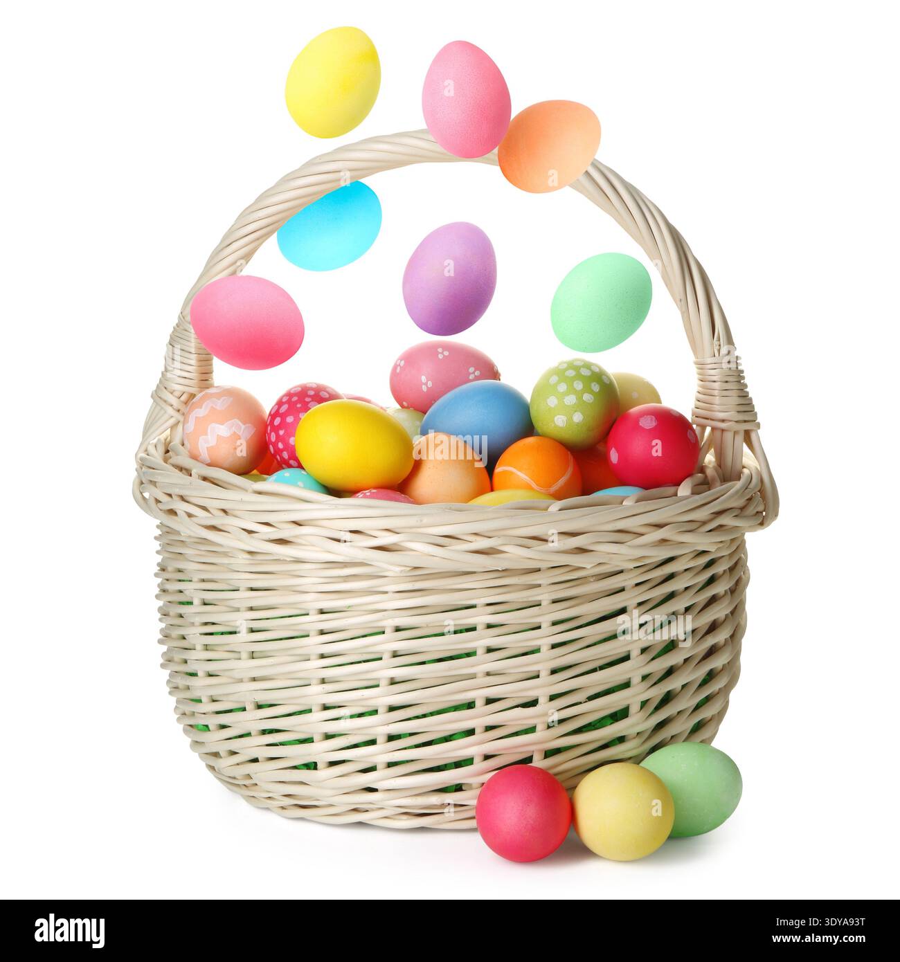 Easter eggs falling into basket on white background Stock Photo