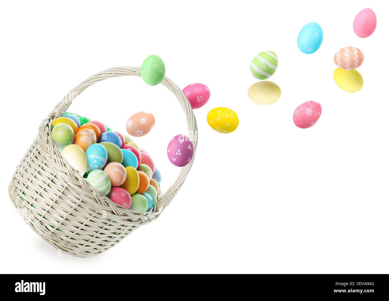 Bright Easter eggs falling into basket on white background Stock Photo