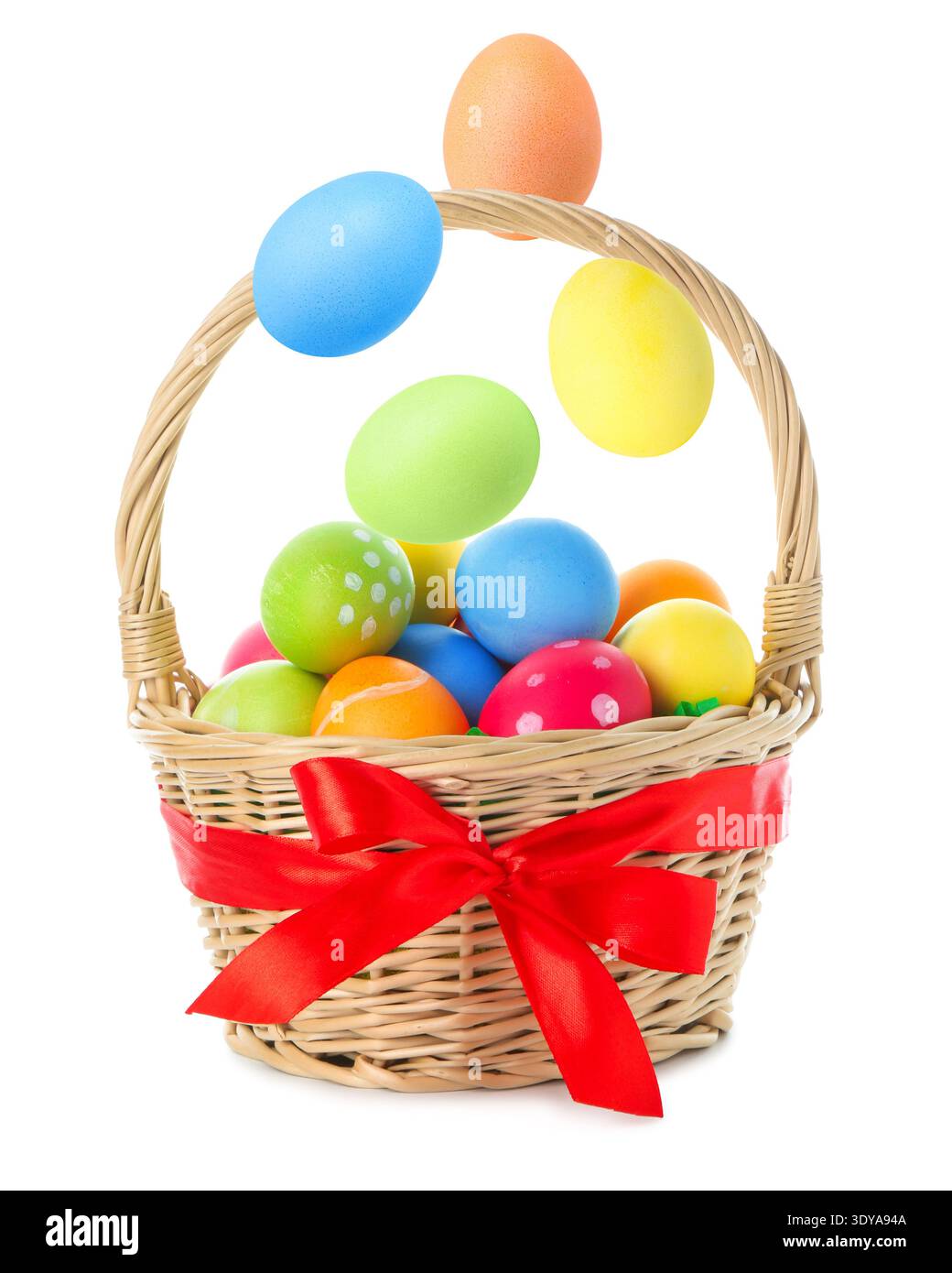 Easter eggs falling into basket on white background Stock Photo