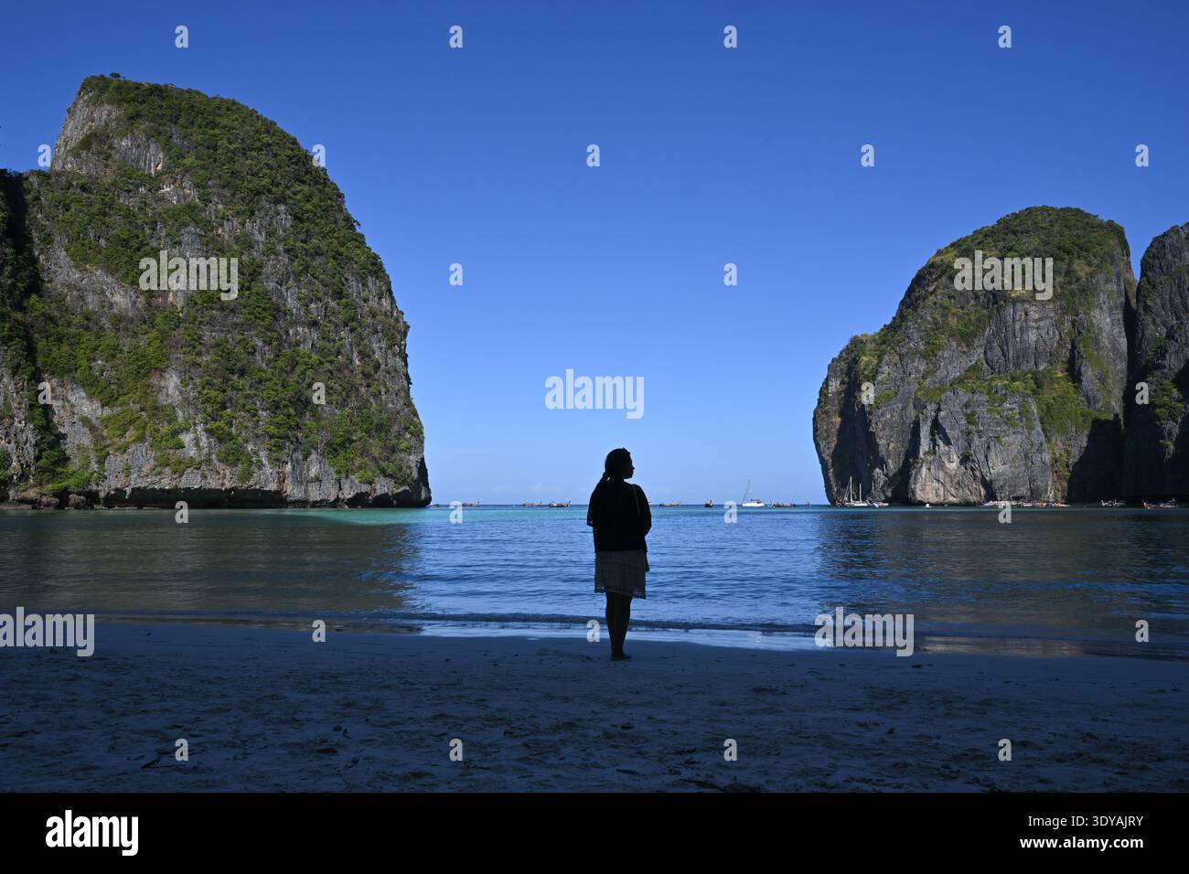 A tourist is seen standing alone on the beach at Maya Bay on Phi Phi ...