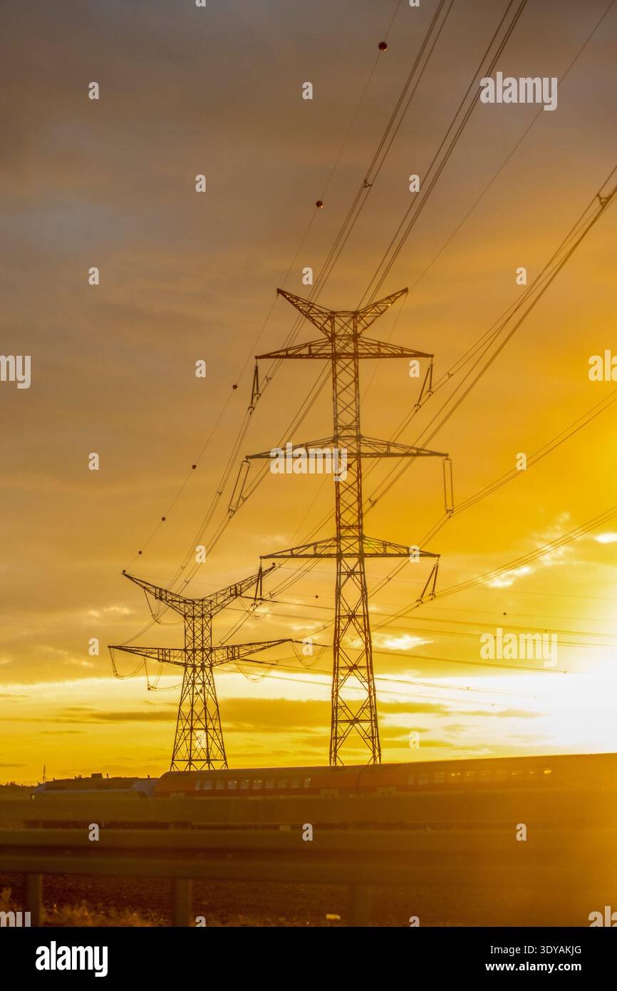 Line of electricity pylons at sunset. Stock Photo