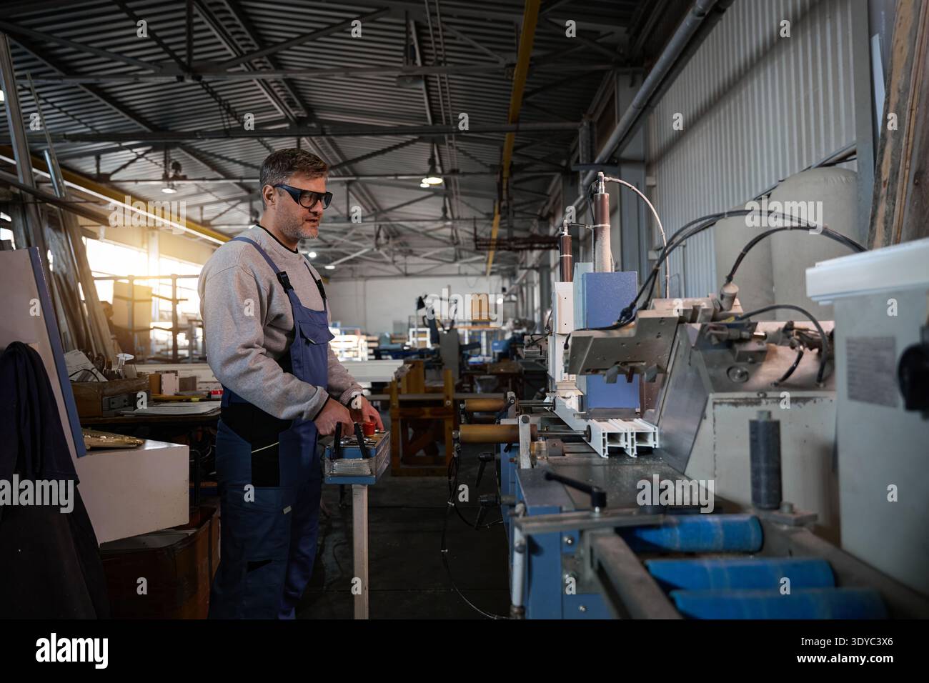 Professional production workers in coverall working with different PVC windows Stock Photo