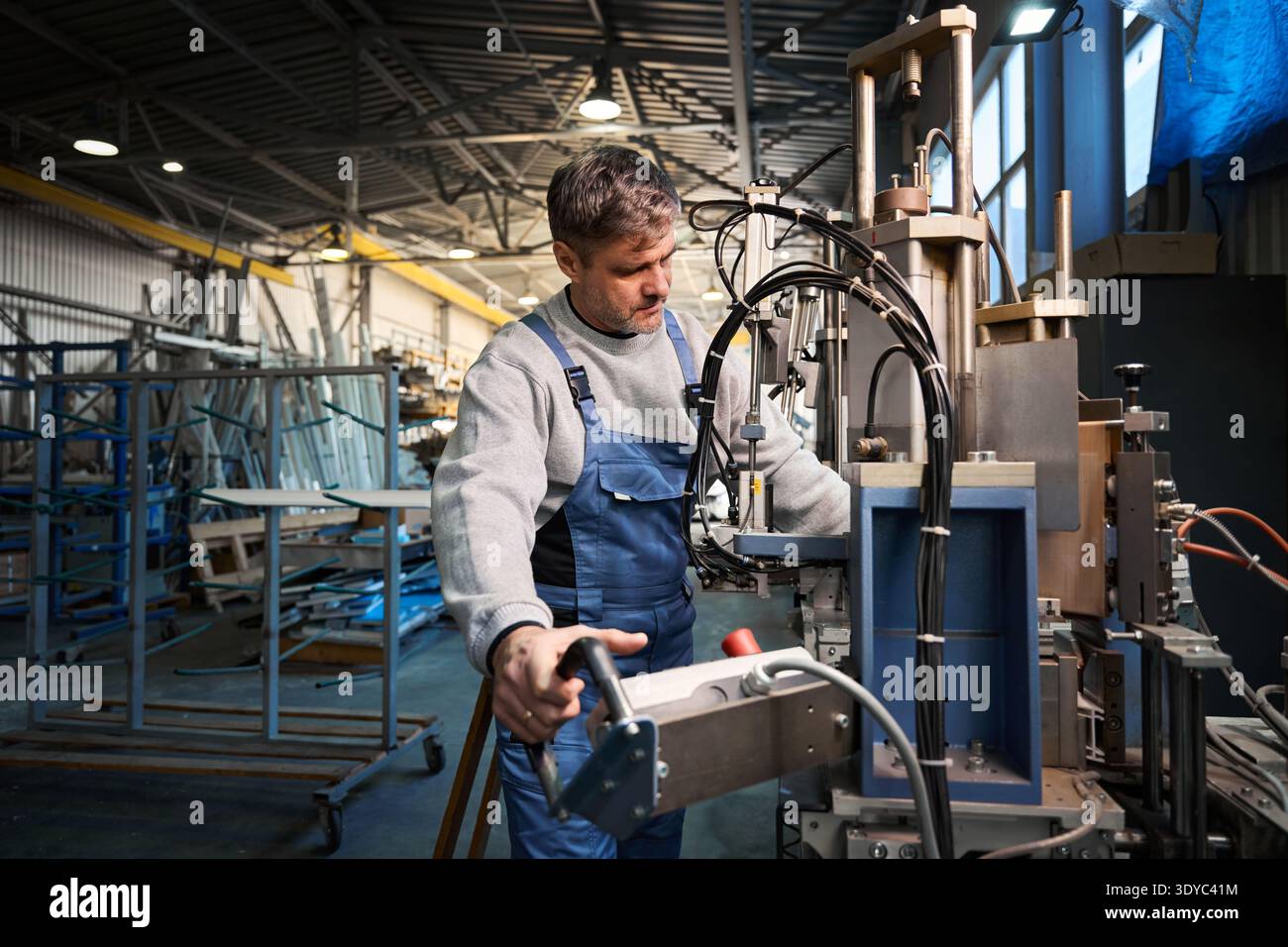 Professional production workers in coverall working with different PVC windows Stock Photo