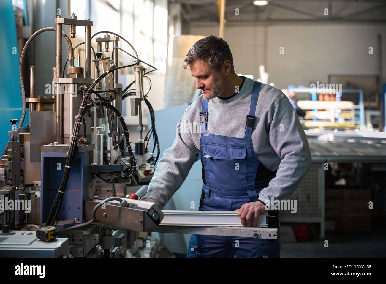Professional production workers in coverall working with different PVC windows Stock Photo