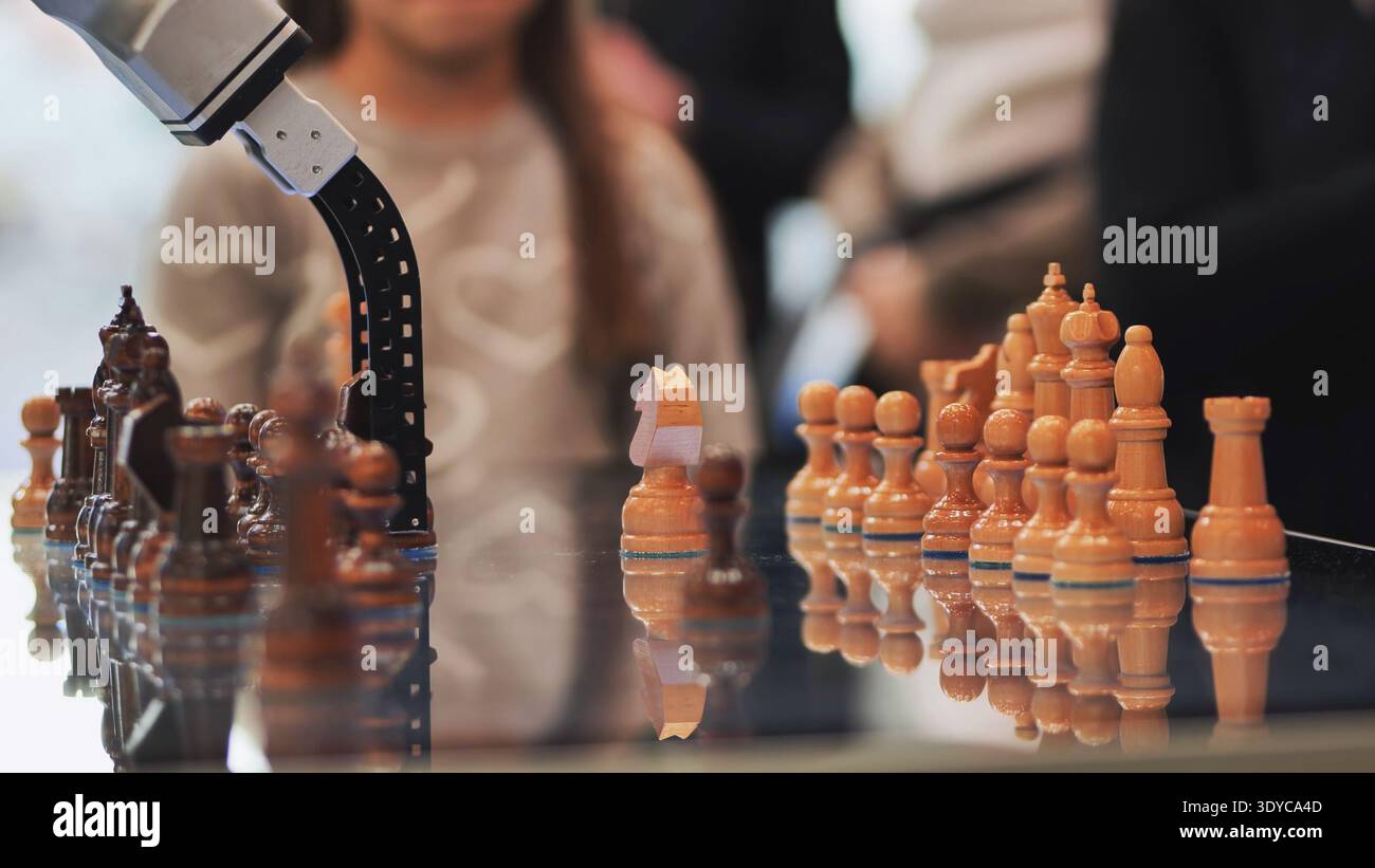 Robot arm playing chess with artificial intelligence and advanced automation Stock Photo