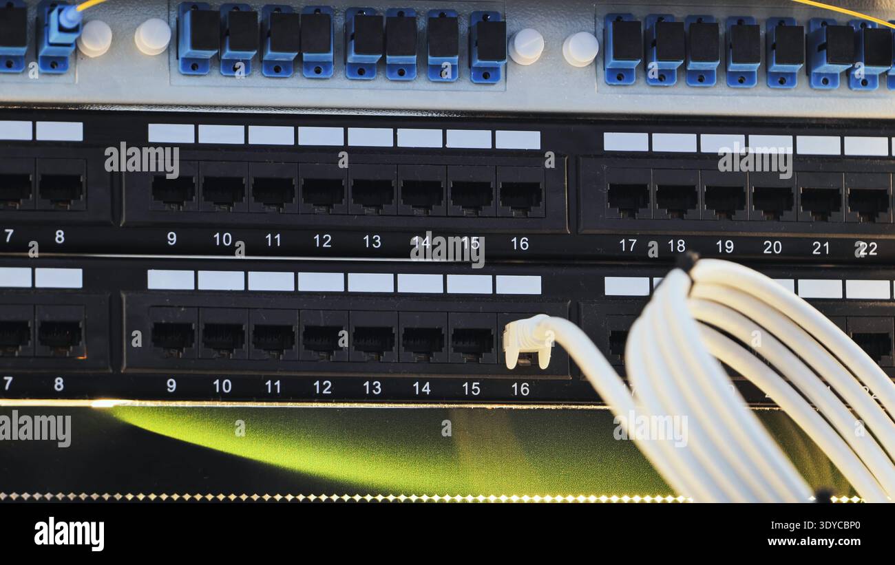 Network cables connecting to patch panel in data center for internet communication Stock Photo