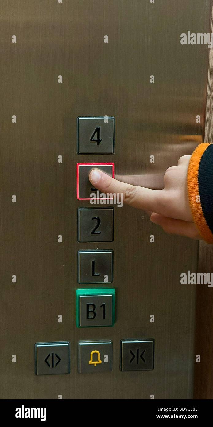 The child is pressing the button in the elevator Stock Photo