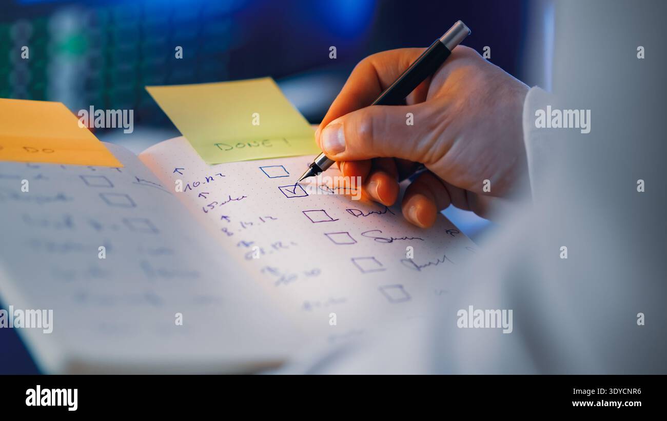 Checklist notebook task completion marking done list. Hand marking completed tasks checklist productivity planning workflow organization concept. Pers Stock Photo