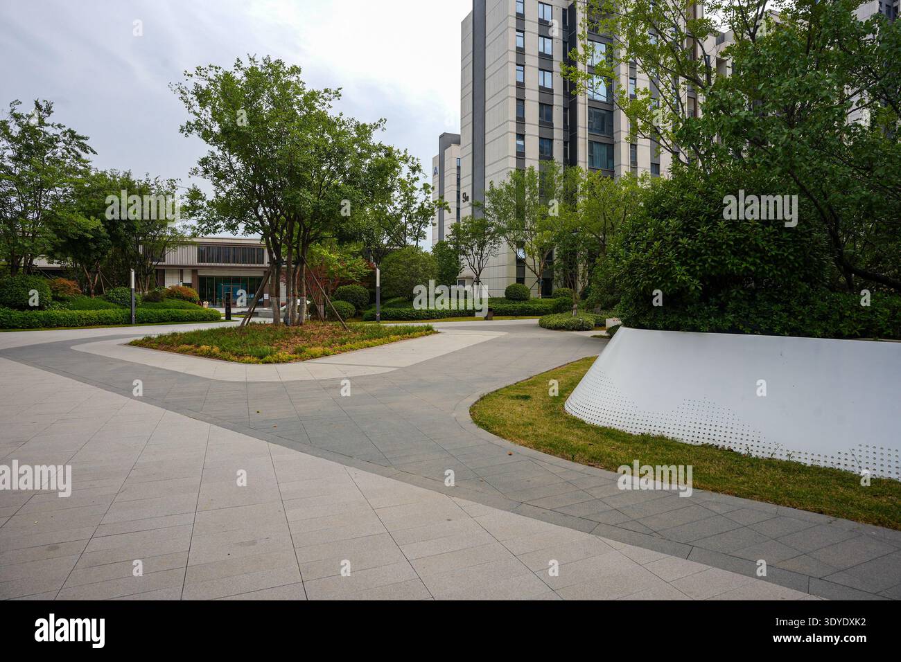 A clean stone pathway winding through a residential park, featuring ...