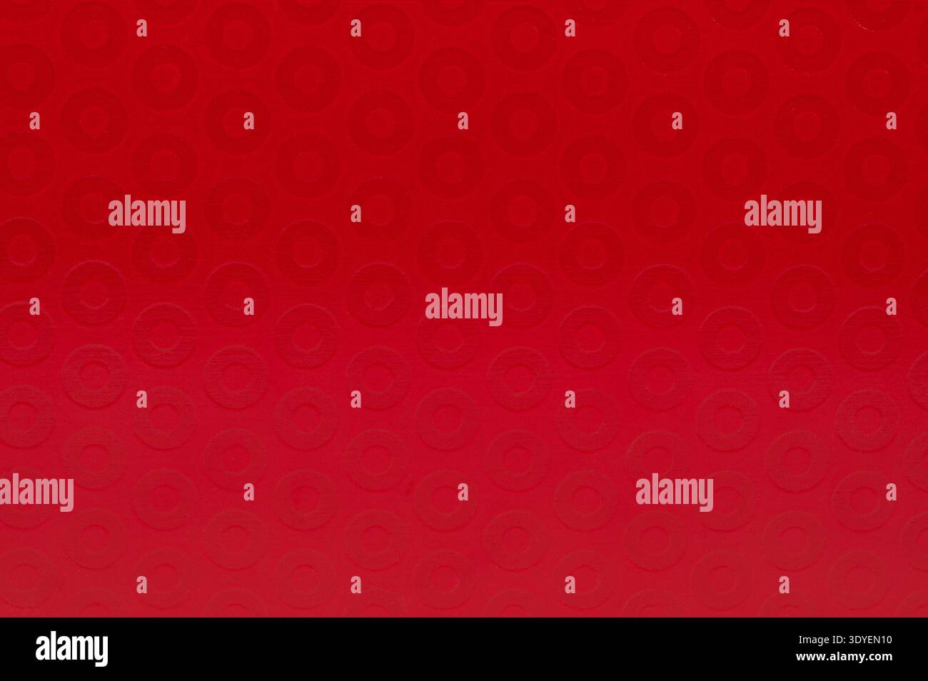 A close view of a bright red surface featuring circular patterns. The ...