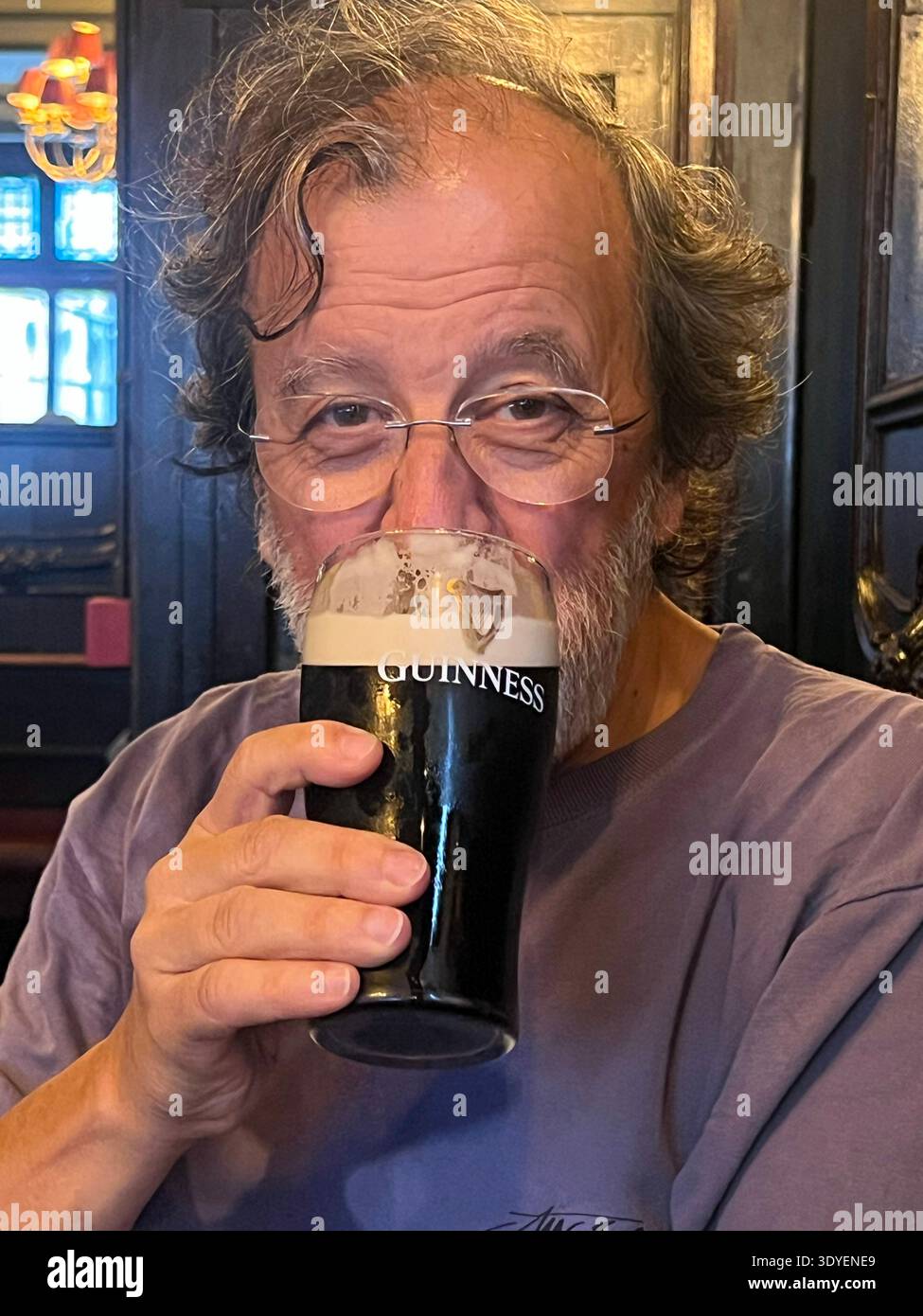 Mature man drinking a Guinness in a pub, Dublin, Ireland - Smartphone Captured Stock Image