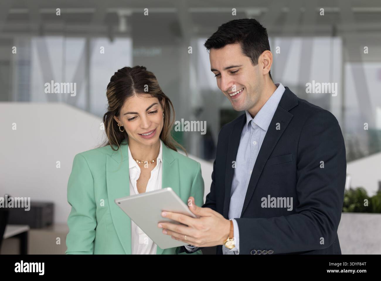 Diverse Hispanic colleagues engaged in teamwork using tablet in office Stock Photo