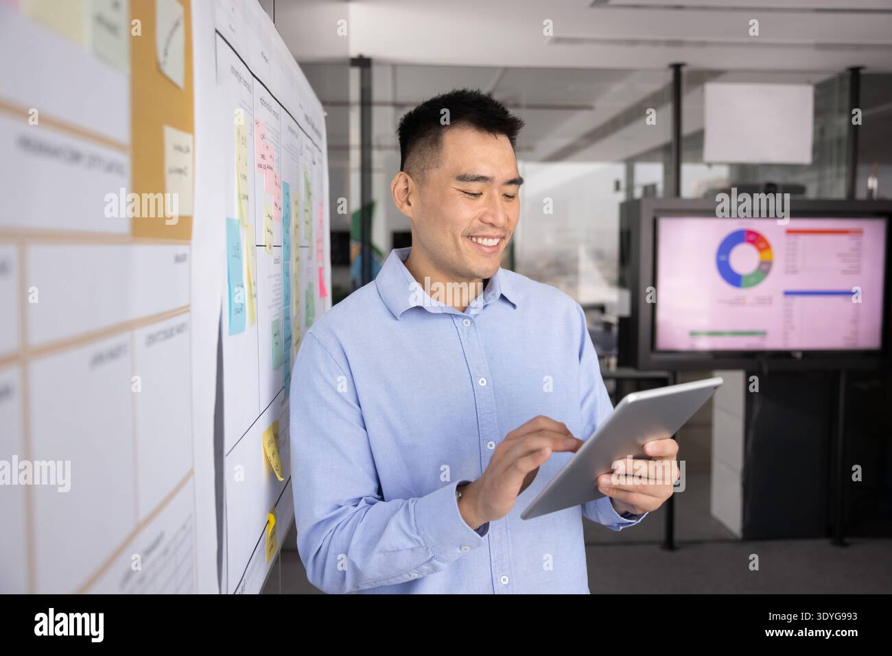 Smart young male professional using digital tablet in modern office Stock Photo