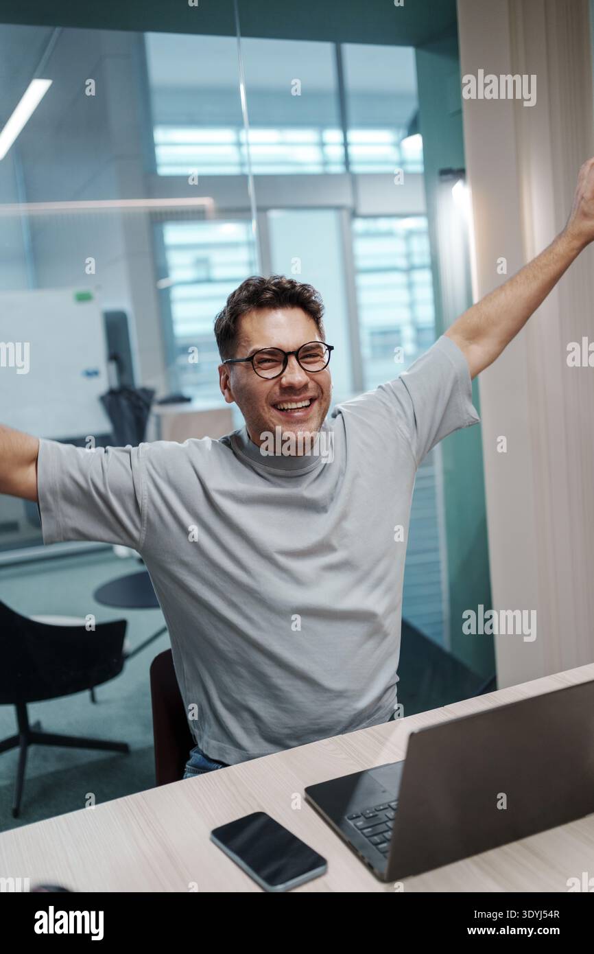 Vigorous Young Professional Displays Triumph And Fulfillment In Contemporary Workspace Following Major Success Stock Photo