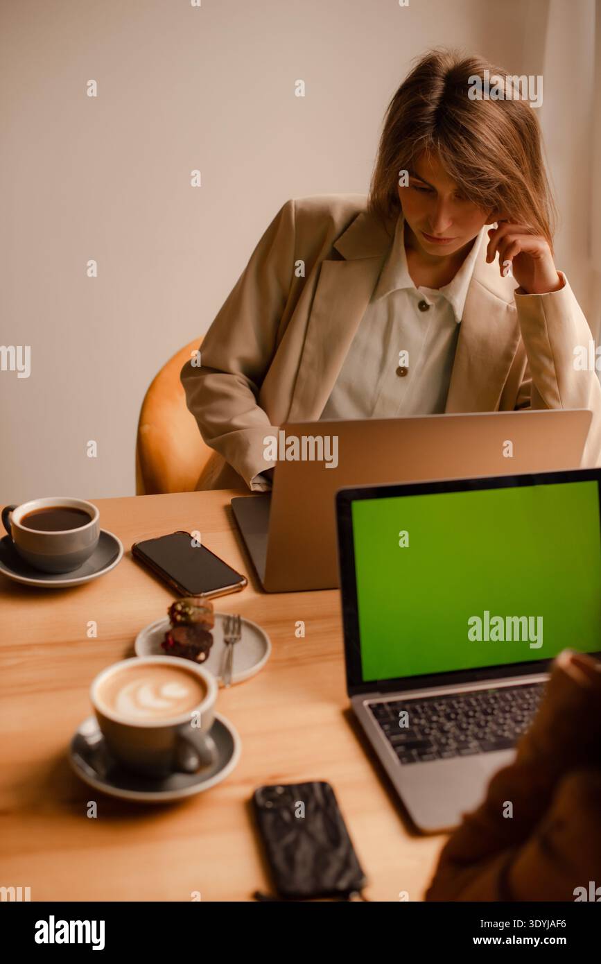 women working remotely together in cozy cafe workspace Stock Photo