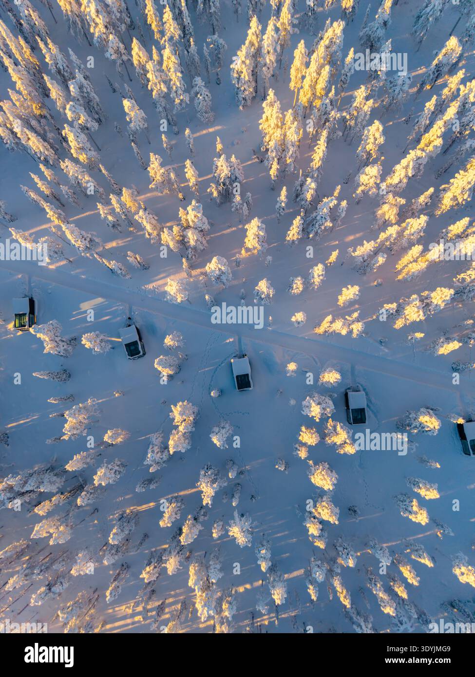 Discover the enchanting winter landscape of Akaslompolo, where snow-covered trees create a beautiful scene. Glimpse the quietude of nature as vehicles Stock Photo