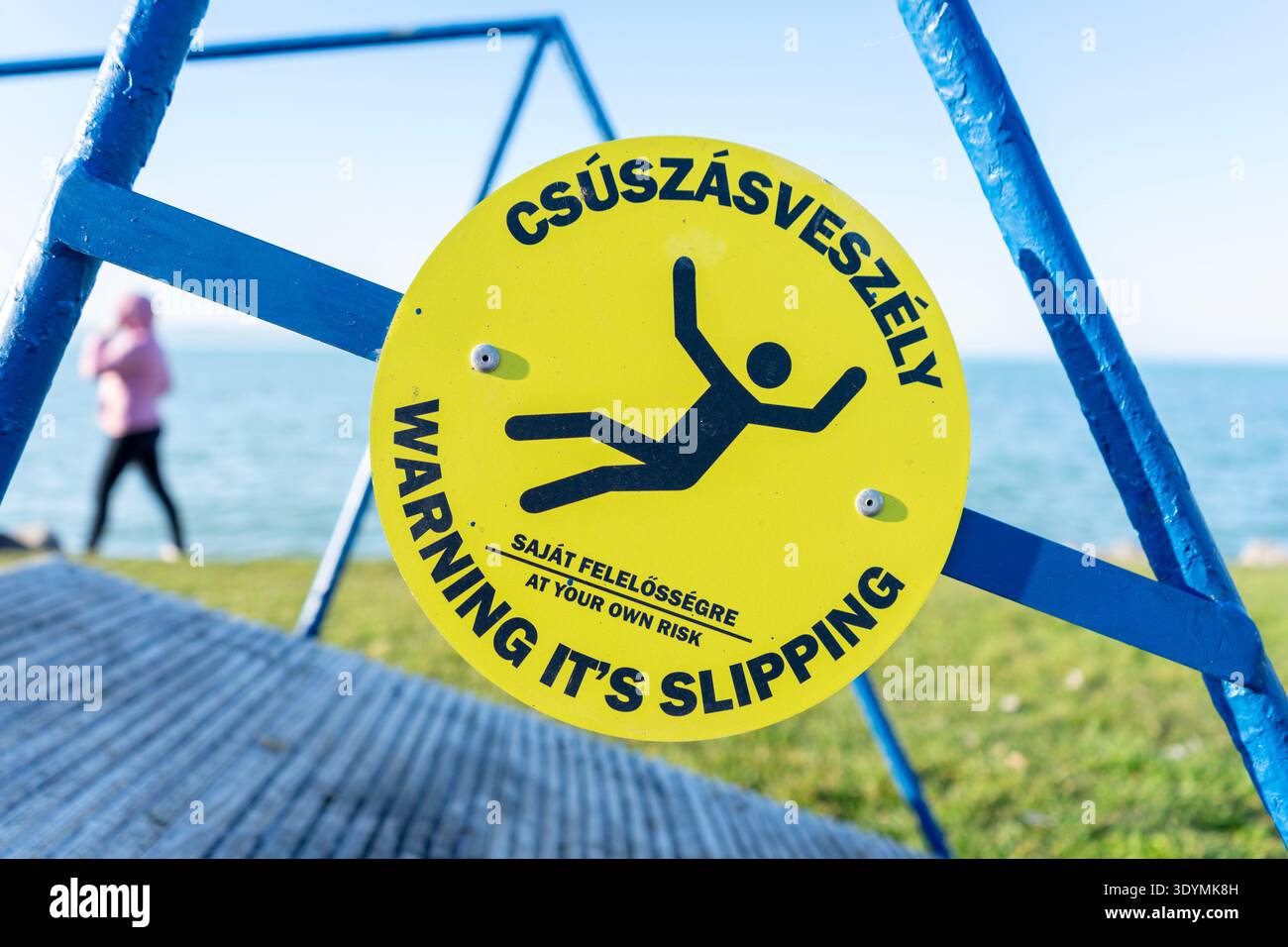 Slip Way Warning Sign Yellow slippery-surface warning sign on a lakeside staircase at Lake ...