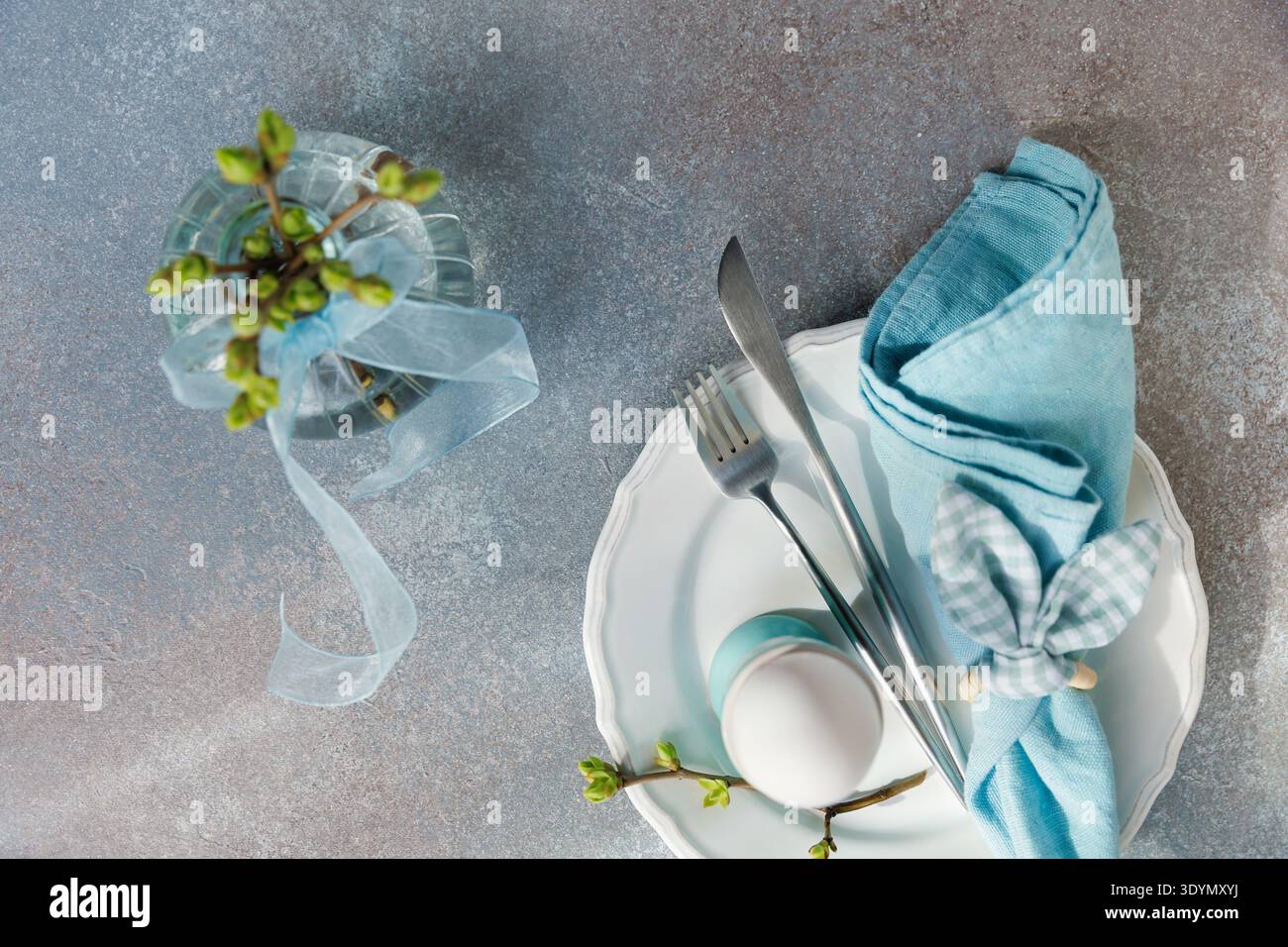 Easter Place Setting with Blue Linen and Buds Stock Photo