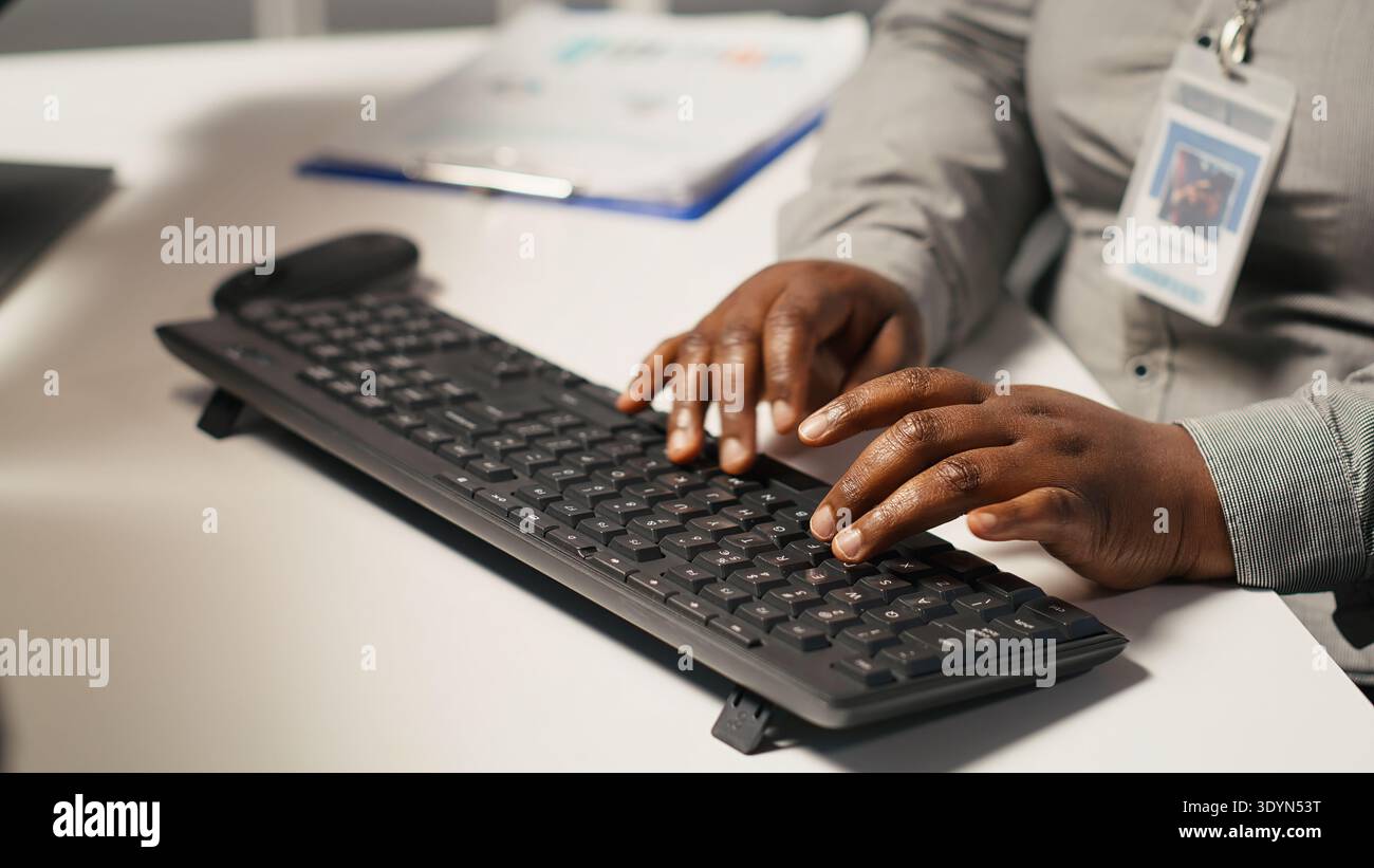 Close up of data center admin coding on PC, doing software updates for AI mainframes. Server farm IT professional typing on computer keyboard, optimizing infrastructure, camera A Stock Photo