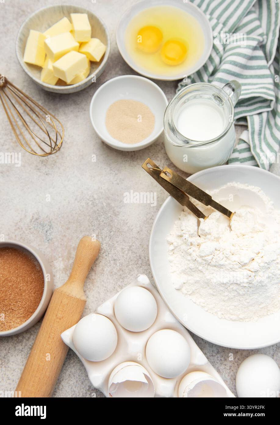 Assorted fresh ingredients for baking dough on a light kitchen counter background Stock Photo