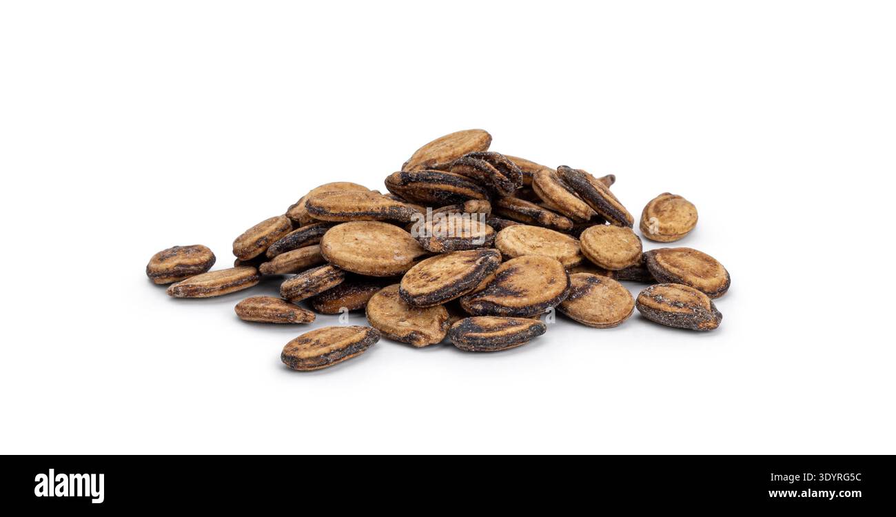 Dried watermelon seeds forming a small pile on a solid white surface Stock Photo