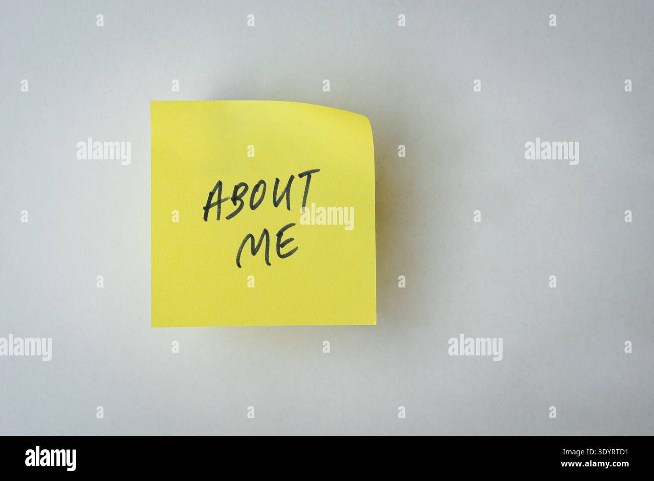 About Me note or message on yellow paper. Isolated on white surface. Stock Photo