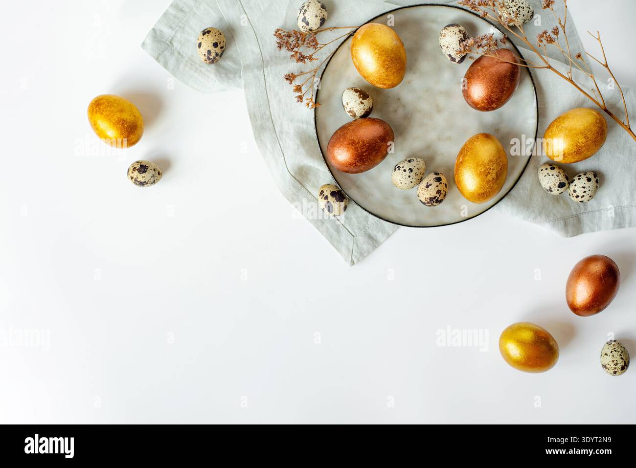 Golden and bronze Easter eggs in a grey plate Stock Photo